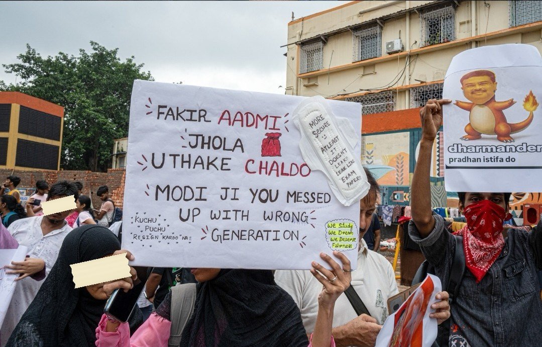 A Charmander poster captioned dharmander, pradhan istifa do, held up in a Kolkata march