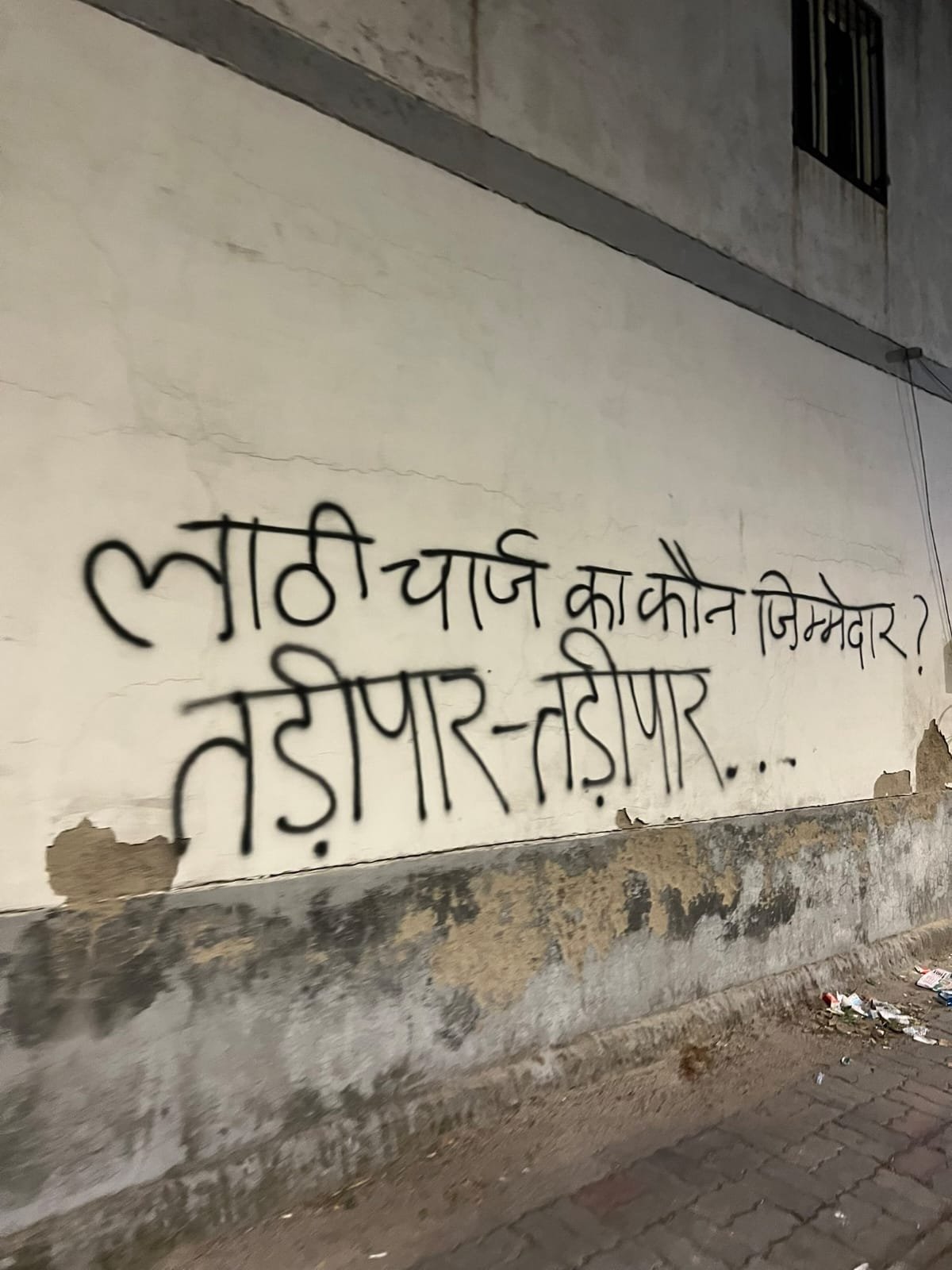 Graffiti in Devanagari asking who is responsible for the lathi charge