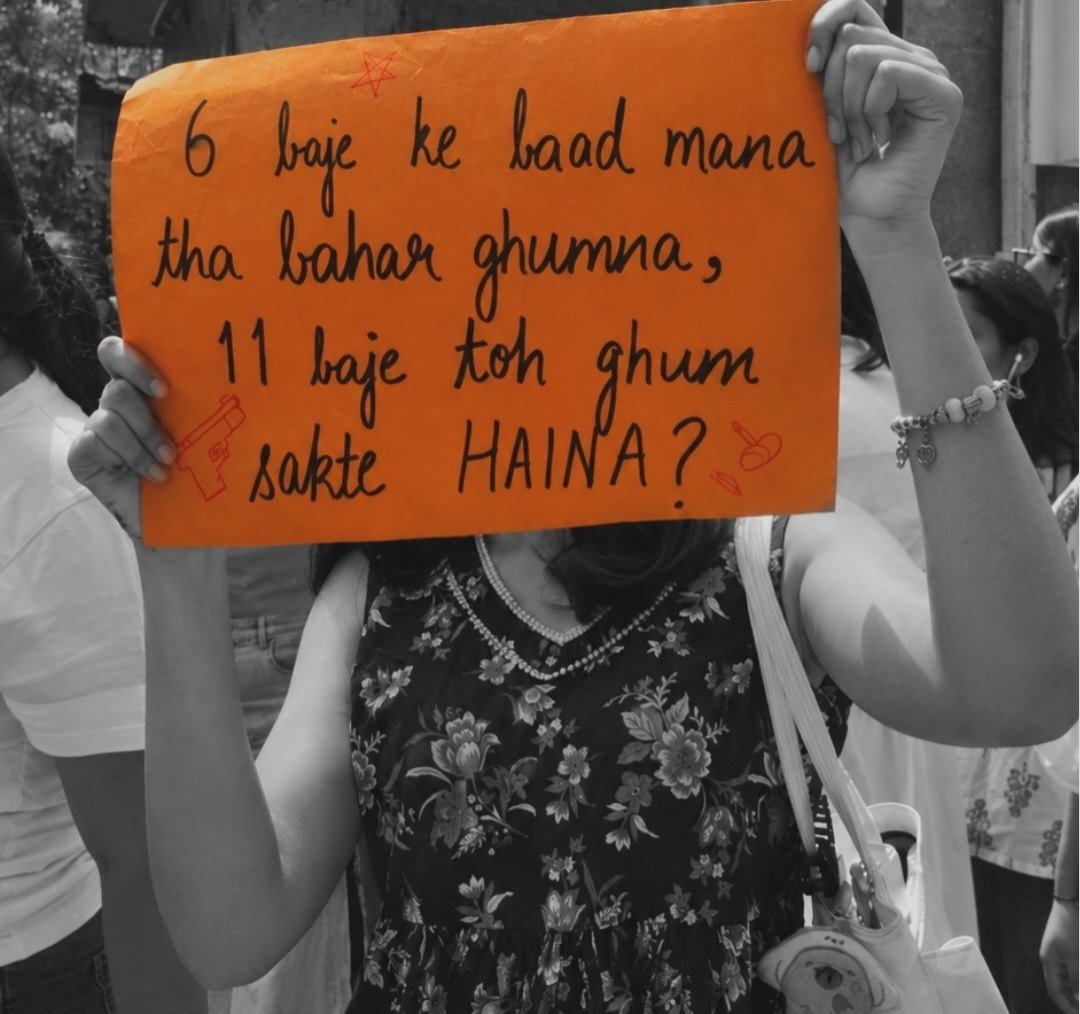 A woman holding an orange placard across her face reading 6 baje ke baad mana tha bahar ghumna, 11 baje toh ghum sakte HAINA? with a small drawn pistol and safety pin.