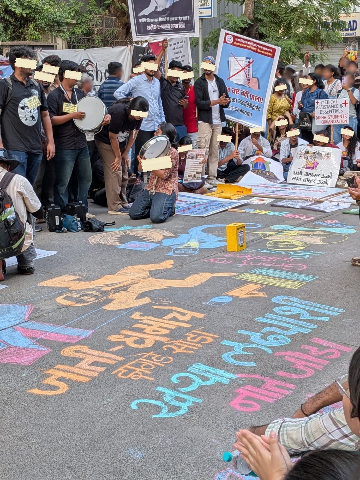 Slogans and a cartoon drawn in coloured chalk across a Mumbai street
