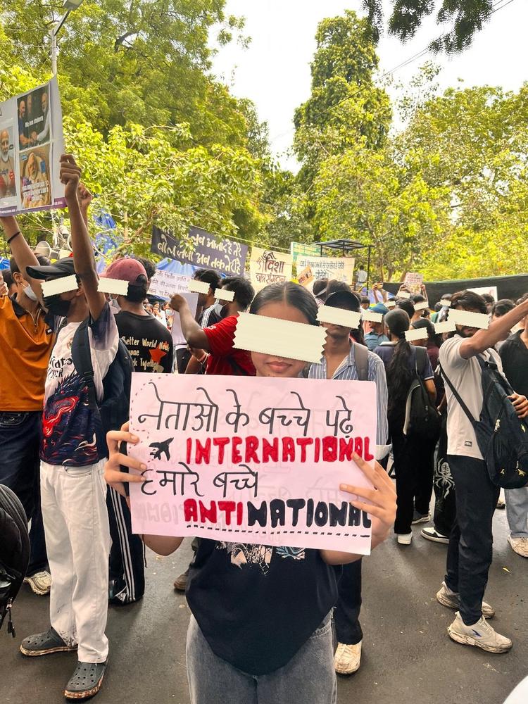 A yellow-bordered placard held up at the Ranchi sit-in reading Hum bhi aaye hai JPSC aur JSSC ki… IYKYK.