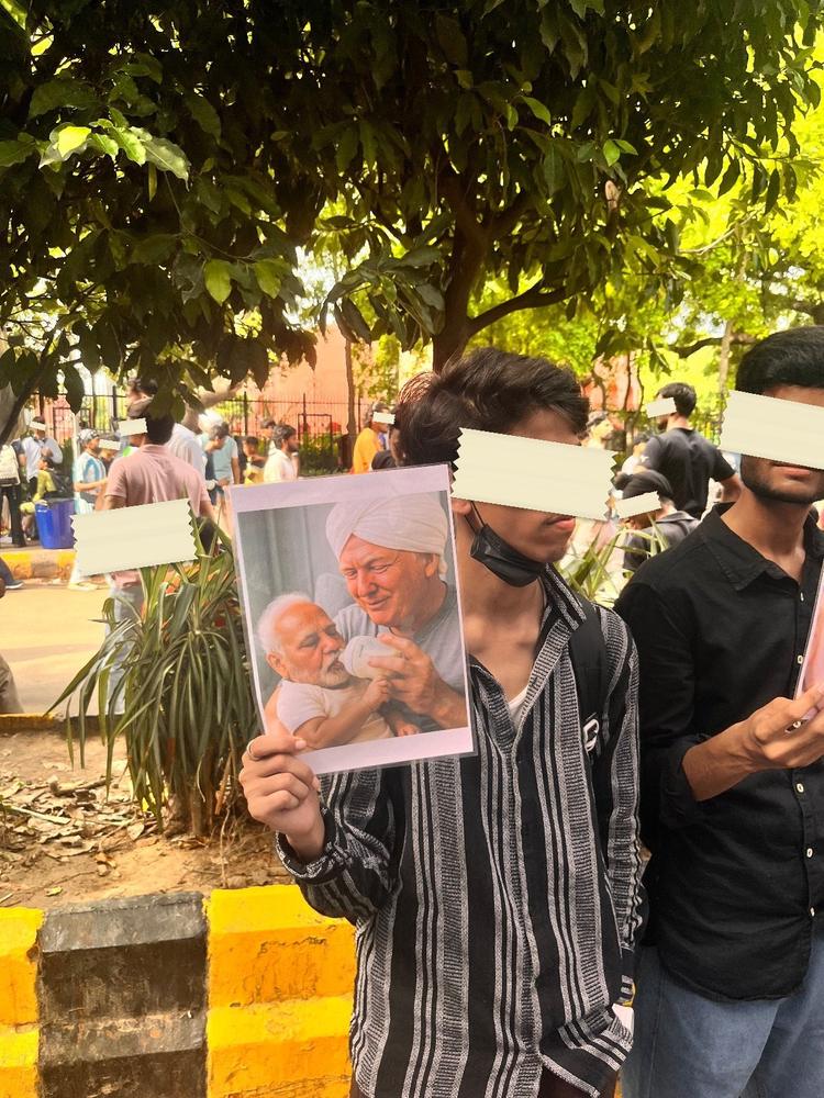 A protester in a full Spider-Man suit at the Ranchi sit-in, carrying a framed portrait of Bhagat Singh on his chest.